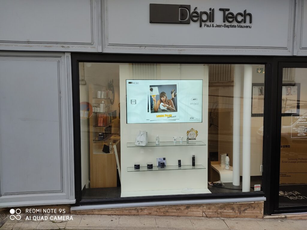 Écran vitrine affichant une promotion Dépil Tech, installation d’affichage dynamique en institut de beauté.