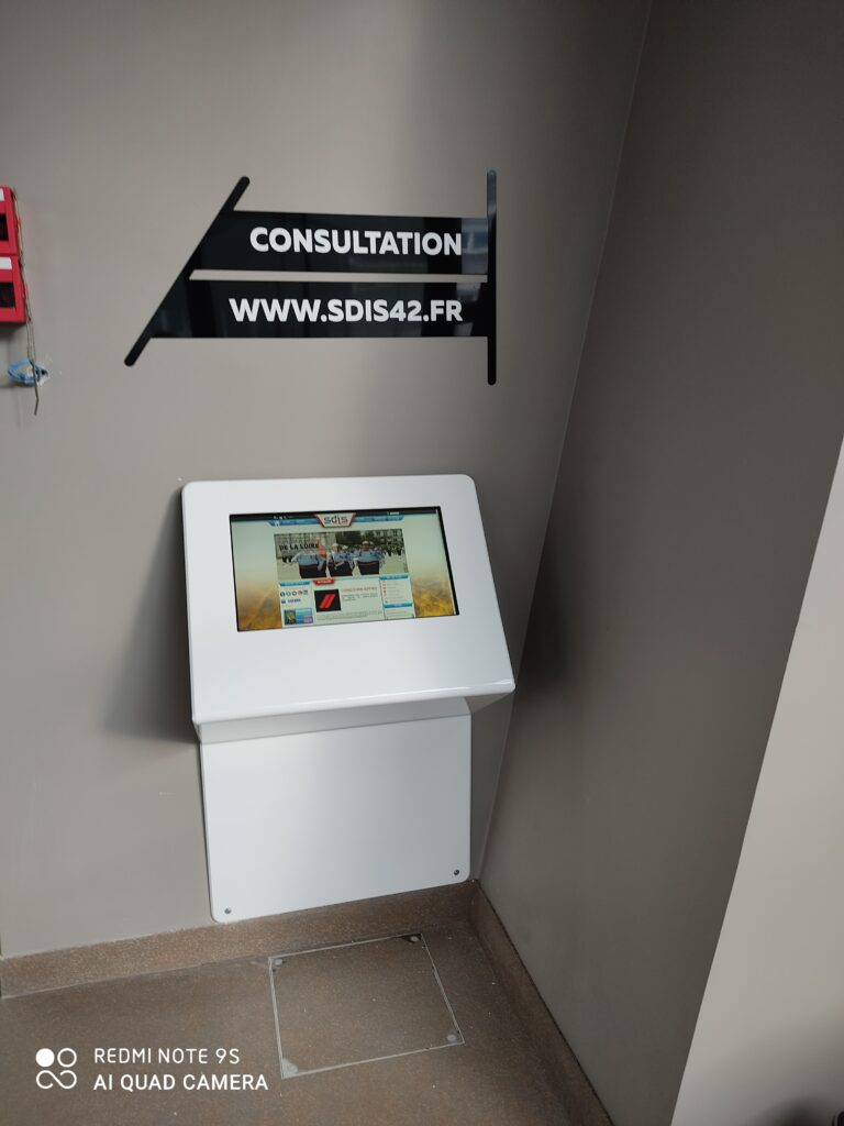 Borne murale de consultation numérique installée dans un espace public pour accès à l’information.