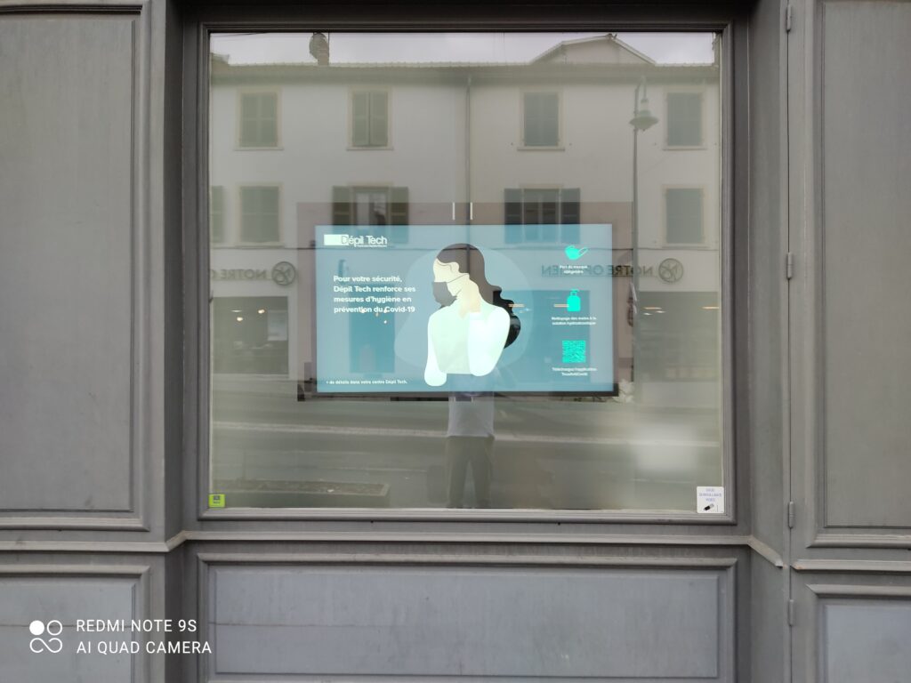 Écran d’affichage dynamique en vitrine diffusant des messages d’hygiène et d’information pour un centre Dépil Tech.