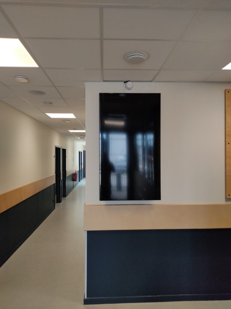 Écran mural installé dans un couloir d’entreprise, prêt pour diffusion d’affichage dynamique.