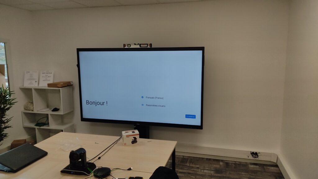 Écran interactif professionnel monté sur support mobile dans une salle de réunion haut de gamme.