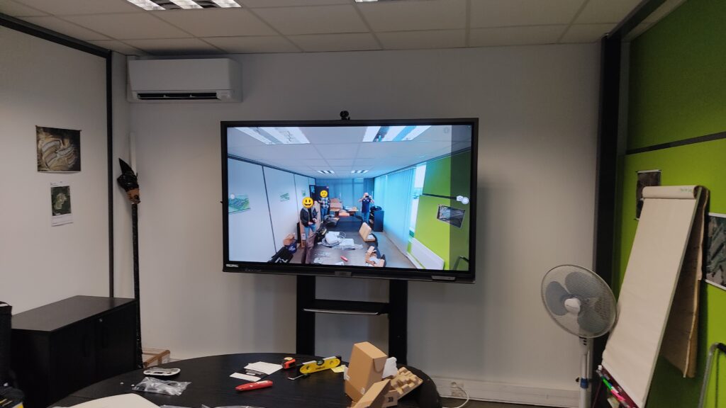 Installation audiovisuelle en cours dans une salle de réunion avec outils et câbles sur la table.